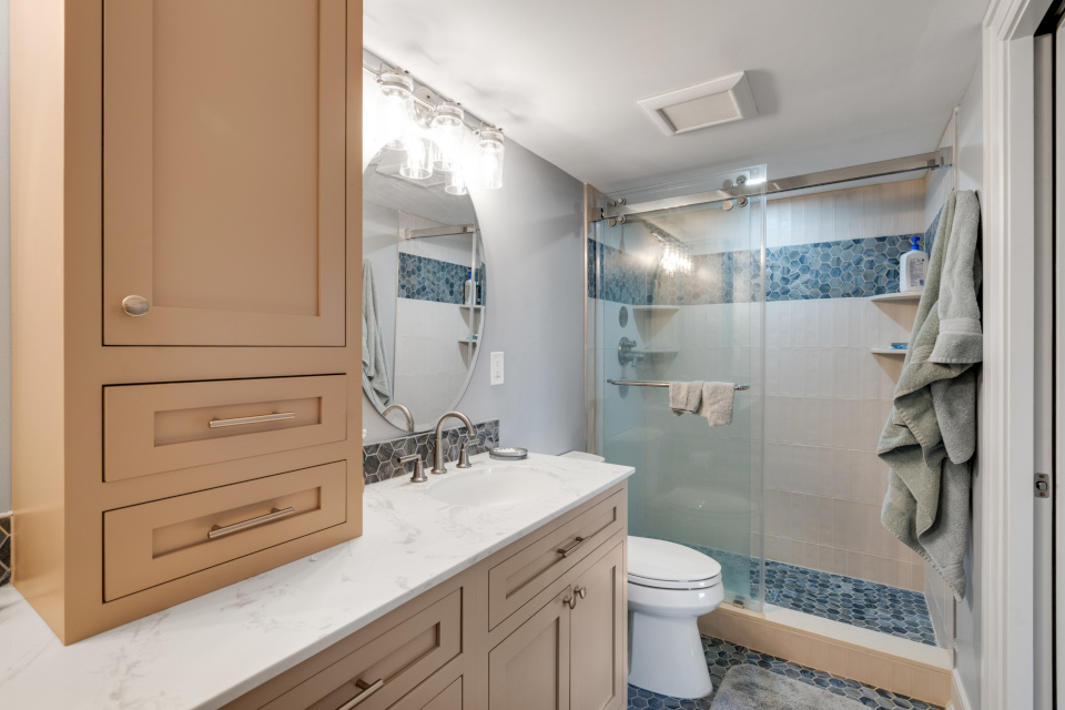 Bathroom. Vertical subway tiles. Decorative accent tiles. Standing shower. Sliding doors. New vanity. Custom vanity. Ample storage space. 
