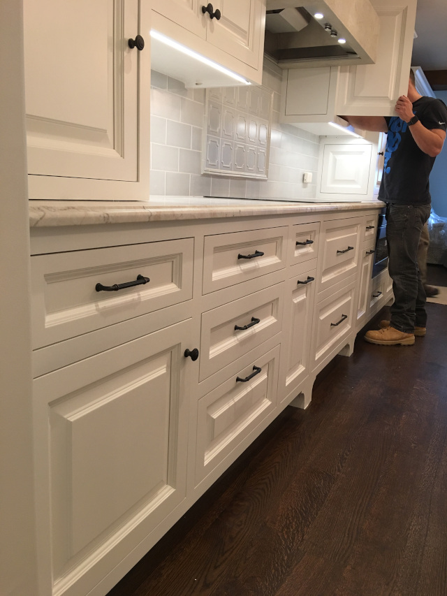 after G & R improved. Dark hardwood floors. Oven range. Range hood. Cohesive kitchen design.  Custom white cabinets. After renovation. Beautiful remodel. 
