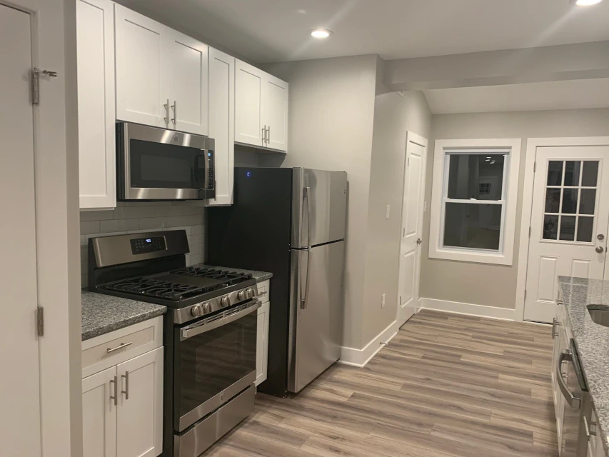 Modern gray kitchen featuring granite countertops and high-performance laminate flooring.
