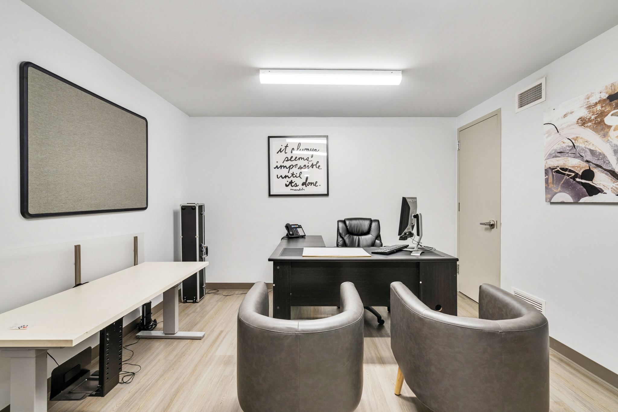 Elongated desk. Energy efficient lighting. Light wood floors. Updated workspace. Office remodel. 