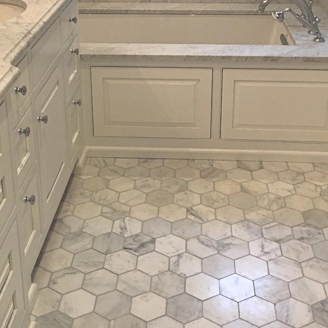 Custom honeycomb tile along floor surrounding a luxurious soaking tub.
